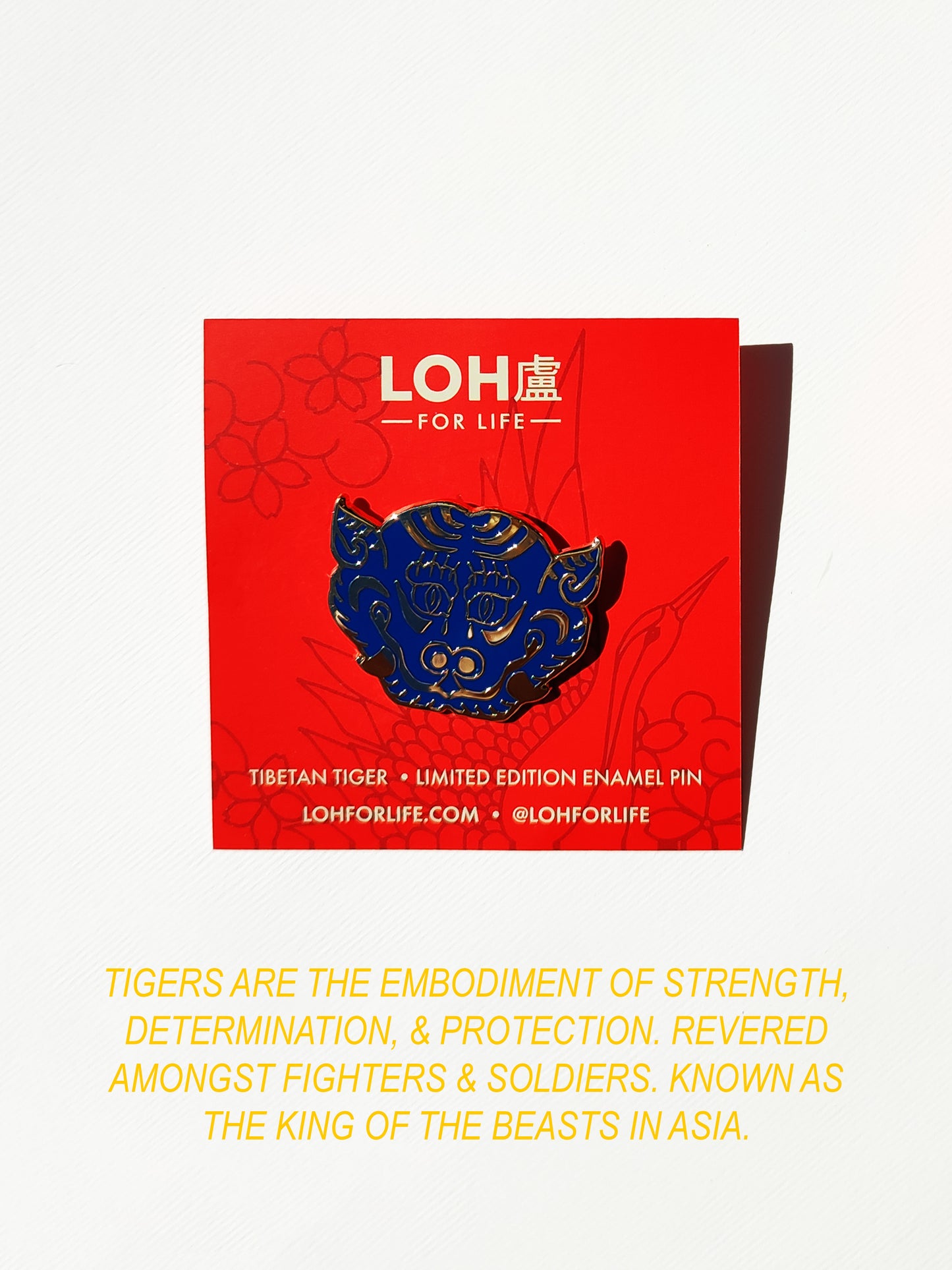 A Tibetan tiger enamel pin in blue and gold is displayed on its red LOH For Life backing card, with a yellow text block below on a white background.